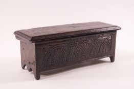 A doll's house oak coffer with carved decoration to front and back and interior divider,
