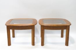 A pair of G-Plan teak coffee tables with inset glass tops, one with label,