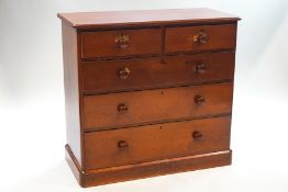 A Victorian stained pine chest of five drawers with turned handles,