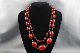 A single strand of graduated cherry amber beads strung on gilt fittings, no clasp.