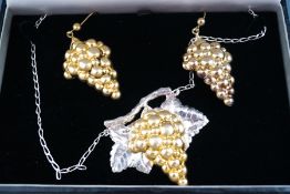 A silver and gilt necklace in the style of a grapevine with matching silver gilt grapevine drop