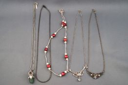 A selection of five silver necklaces consisting of two blue topaz centrepiece necklaces and three
