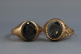 A selection of two yellow gold signet rings each set with a carved hematite intaglio.