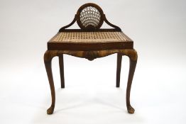 A small mahogany and cane stool with shaped apron, on slender cabriole legs,