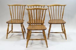 A set of four Ercol blonde wood stick back kitchen chairs,
