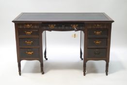 A Victorian mahogany writing desk with blue leather inset writing surface and nine drawers,