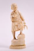 An early 20th century Japanese ivory okimono, carved as a peasant with a fork,