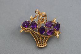 A late twentieth century yellow metal brooch stylized as a basket of flowers claw set with six oval