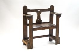 A late Victorian oak hall bench/stick stand with carved leaf detail to back rail,