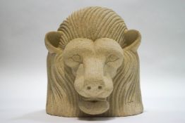 A hand carved stone figure depicting a lion's head,