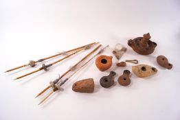 A collection of Roman items, including oil lamps, lamp filler, spindle whorls,