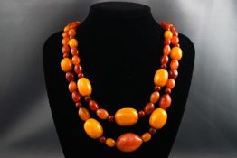 A double strand of butterscotch and orange amber beaded necklace,