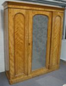 A Victorian satinbirch triple wardrobe, with mirror door enclosing a hanging rail and hooks,