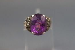 A yellow and white metal dress ring set with an oval natural amethyst measuring 14.0mm x 11.