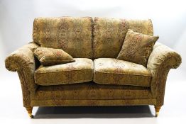 A modern Parker Knoll two seater sofa with tapestry style upholstery and cushions,