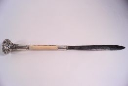 A decorative letter opener with late Victorian carved ivory and white metal handle,