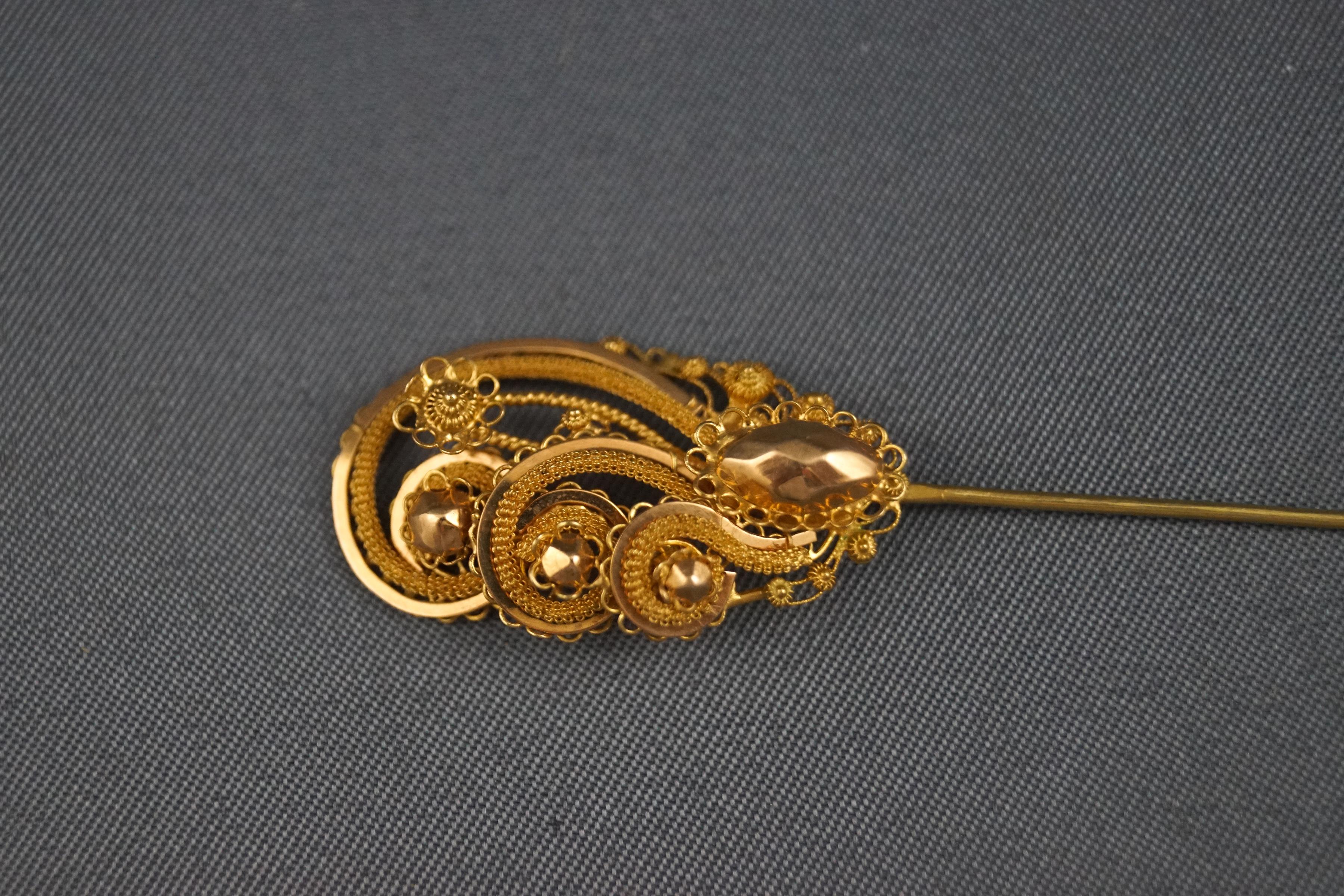 A yellow metal hat pin with filigree and beaded design. Tested as 22ct gold. 2.