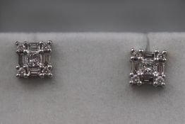 A pair of 18ct white gold diamond ear studs set with round brilliant cut and baguette diamonds.
