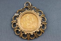 A full gold Sovereign, 1910 with an abstract mount. Hallmarked 9ct gold, London, 1974. 13.