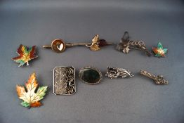 A selection of ten silver brooches consisting of three variable sized enamelled leaf,