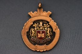 A rose gold enamelled shield pendant. Hallmarked 9ct gold, Chester, 1925. 7.