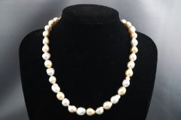 A single strand of baroque cultured freshwater yellow and white pearls with silver gilt push in