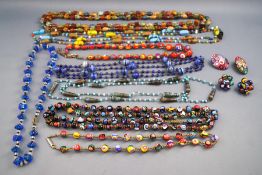 A collection of eight necklaces and two pairs of clip on earrings with the majority being mille