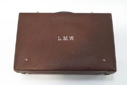 A Victorian leather dressing case containing four silver mounted bottles, the case monogrammed L.M.