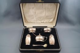 A silver five piece cruet, the salts and the mustard pot with blue glass liners, in fitted case,