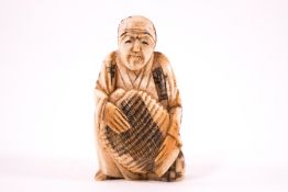 An early 20th century Japanese ivory netsuke of a robed man, unsigned,