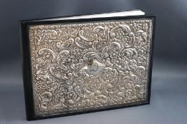 A silver mounted leather bound address book, the cover embossed with flowers, C scrolls,