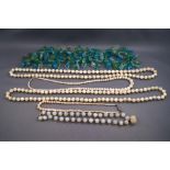 A green and blue glass bead necklace, four mother of pearl necklaces and white beaded necklace.