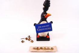 A Guinness advertising pottery table lamp, modelled as a penguin holding a 'Draught Guinness' sign,
