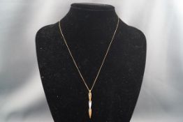 A bi-colour gold pendant in the form of three stylised arrow-heads, stamped '9k',