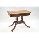 A 19th century cross-banded mahogany tea table on four spindle supports and reeded outswept legs,