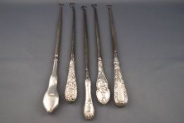 Five silver handled button hooks, comprising; a plain exampled with a shaped wavy handle,