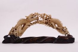 An early 20th century Chinese ivory boar's tusk, carved as a dragon among the clouds, 17cm long,