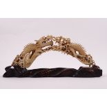 An early 20th century Chinese ivory boar's tusk, carved as a dragon among the clouds, 17cm long,