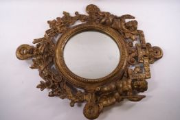 A cast and gilded metal wall mirror, the surround modelled as two cherubs and foliate swags,