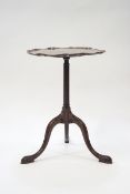 A mahogany occasional table, the pie crust top on fluted pedestal with tripod scroll legs, 58.