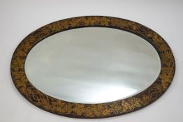 A late Victorian oval wall mirror with vine leaf decoration in relief, 65.