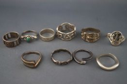 A collection of ten silver and white metal rings in various designs including: an oval signet ring