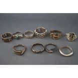 A collection of ten silver and white metal rings in various designs including: an oval signet ring