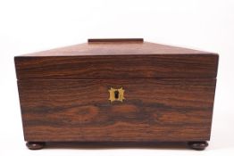 A 19th century rosewood tea caddy of sarcophagus form with ring handles,