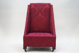 An Edwardian nursing chair of unusual angular form, raised floral patterned deep pink fabric,