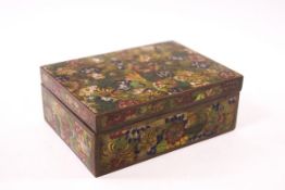 A rectangular cloisonne box with various flower heads on a green ground, 12cm wide.
