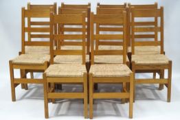 An set of ten oak ladder back dining chairs, each with drop in rush seats and square legs,