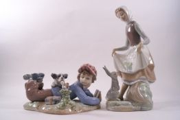 A Lladro figure of a boy with his dog reading, 18cm wide,
