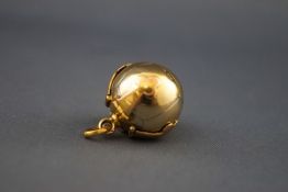 An early 20th century gold-plated 'Masonic ball' pendant with gothic trefoil terminated straps and