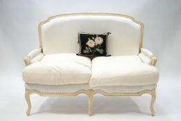 A 20th century French style two seater sofa, painted cream, 96cm high x 137cm wide,